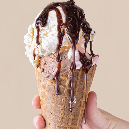 ice cream cone with chocolate syrup dripping down